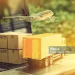 Caixas, caminhão e avião sobre um laptop
